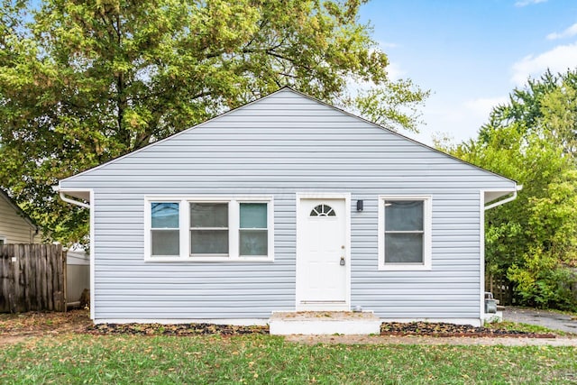 bungalow featuring a front yard and fence