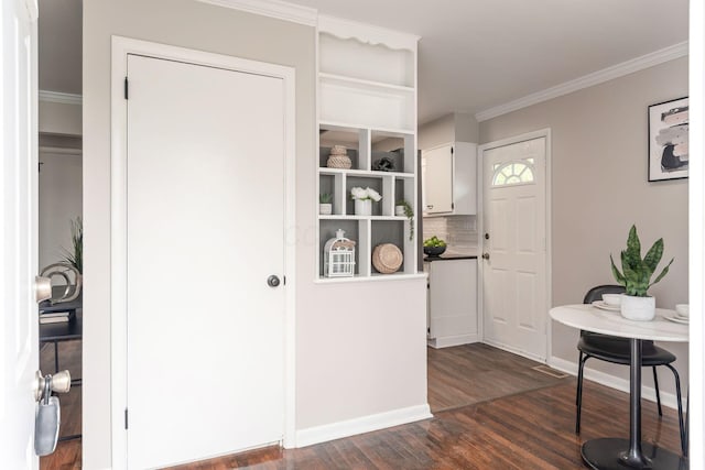 entryway featuring ornamental molding, baseboards, and dark wood-style floors