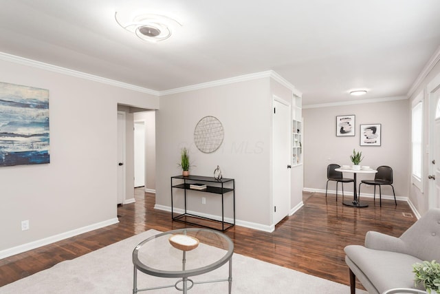 living area with ornamental molding, wood finished floors, and baseboards