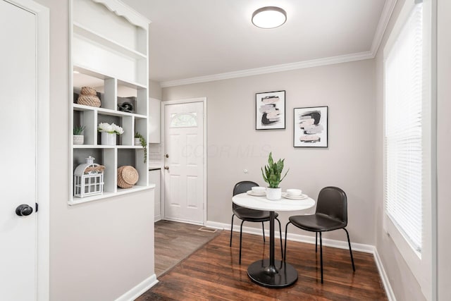 dining room featuring baseboards, dark wood-type flooring, and crown molding