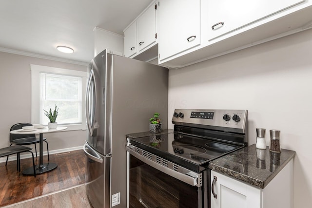 kitchen with baseboards, white cabinets, ornamental molding, dark wood-style flooring, and stainless steel appliances