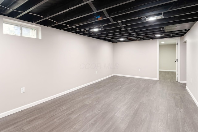 basement with baseboards and wood finished floors