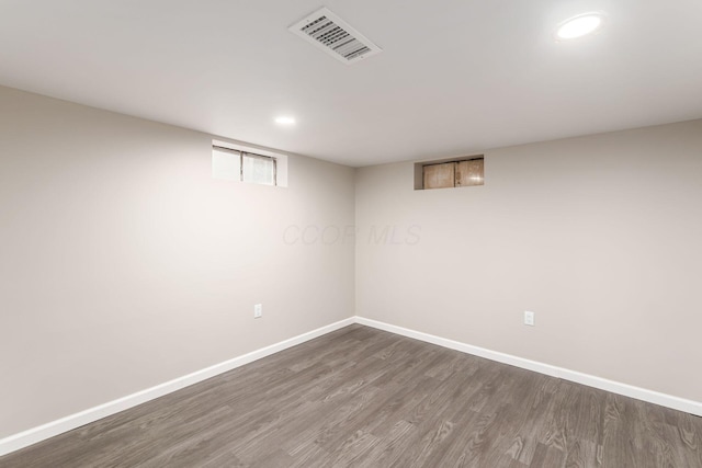 basement with dark wood-style floors, recessed lighting, visible vents, and baseboards