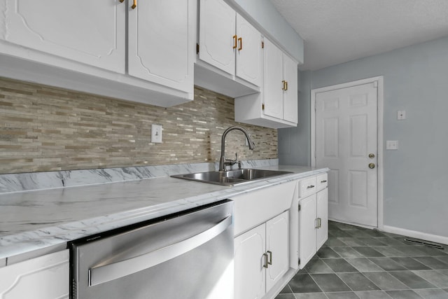 kitchen featuring a sink, white cabinetry, baseboards, stainless steel dishwasher, and decorative backsplash