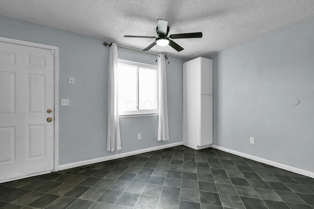 unfurnished room featuring ceiling fan, a textured ceiling, and baseboards