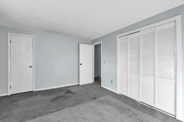 unfurnished bedroom featuring a textured ceiling, carpet flooring, and baseboards