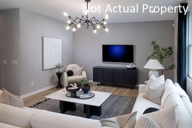 177 Reneau Ave Lot 42, Galloway, OH 43119 - living area with wood finished floors, baseboards, and a notable chandelier