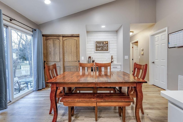 dining area featuring lofted ceiling, light wood-style flooring, and recessed lighting