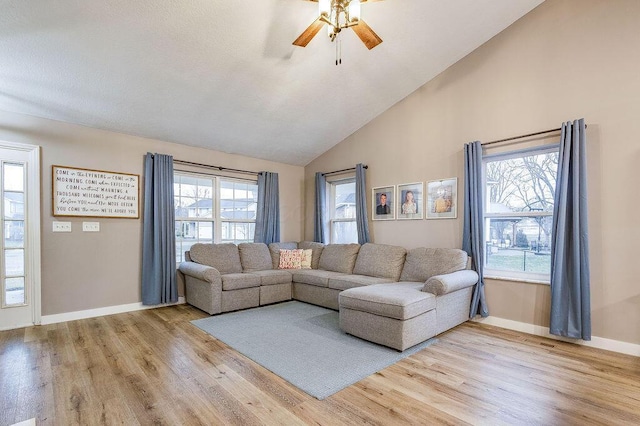 living room featuring light wood-type flooring, baseboards, a ceiling fan, and lofted ceiling