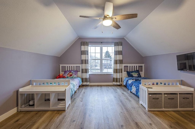 unfurnished bedroom with vaulted ceiling, wood finished floors, and baseboards