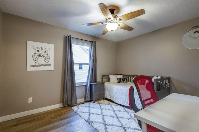 bedroom with a textured ceiling, wood finished floors, a ceiling fan, and baseboards