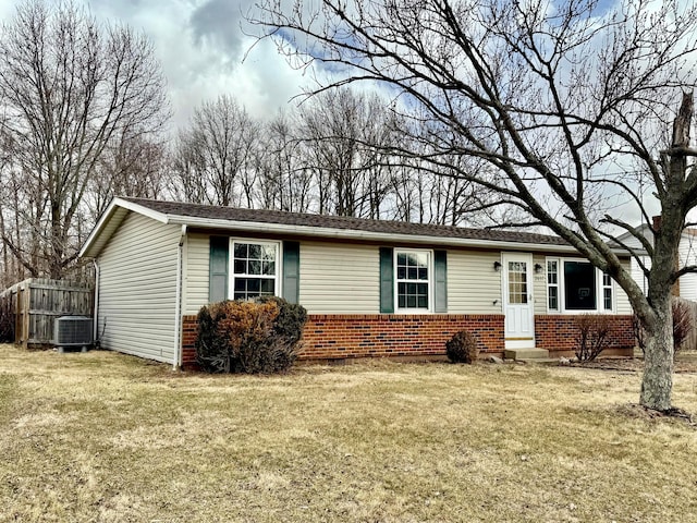 ranch-style house featuring brick siding, a front lawn, and fence