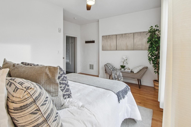 bedroom featuring baseboards, visible vents, ceiling fan, and light wood finished floors