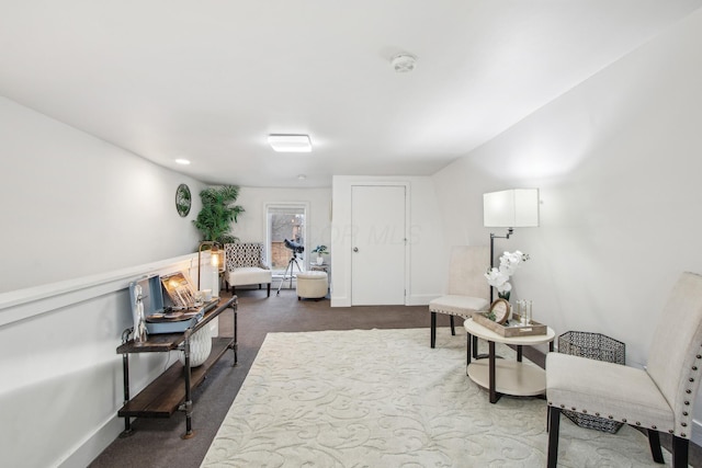 living area featuring baseboards and carpet flooring