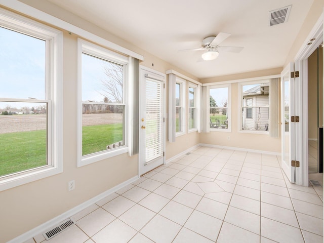 unfurnished sunroom with a ceiling fan and visible vents