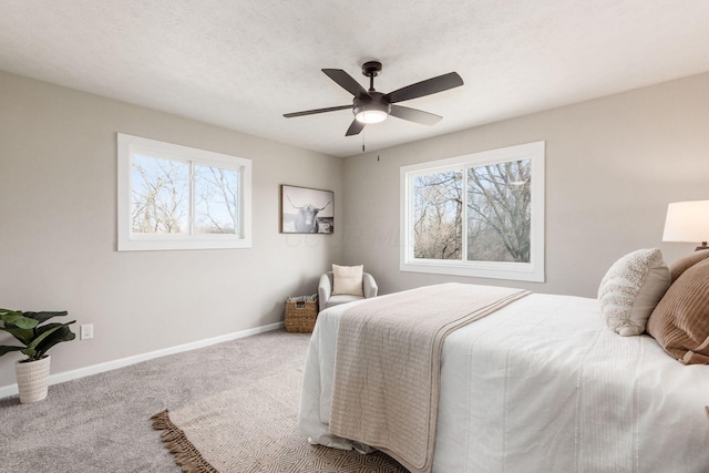 bedroom with carpet floors, multiple windows, a ceiling fan, and baseboards