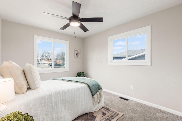 carpeted bedroom featuring ceiling fan, visible vents, and baseboards