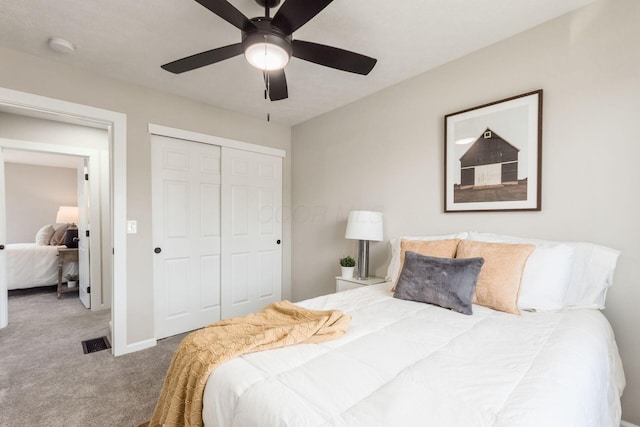 carpeted bedroom featuring a ceiling fan, a closet, visible vents, and baseboards