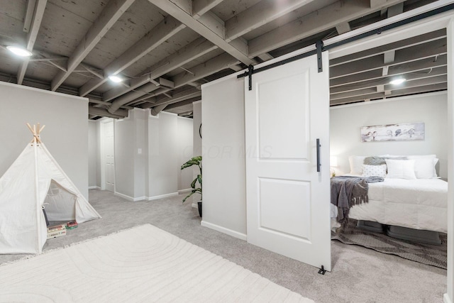 finished basement featuring carpet floors, a barn door, and baseboards