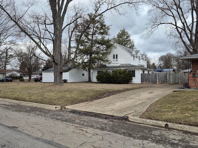 view of property exterior with fence and a yard