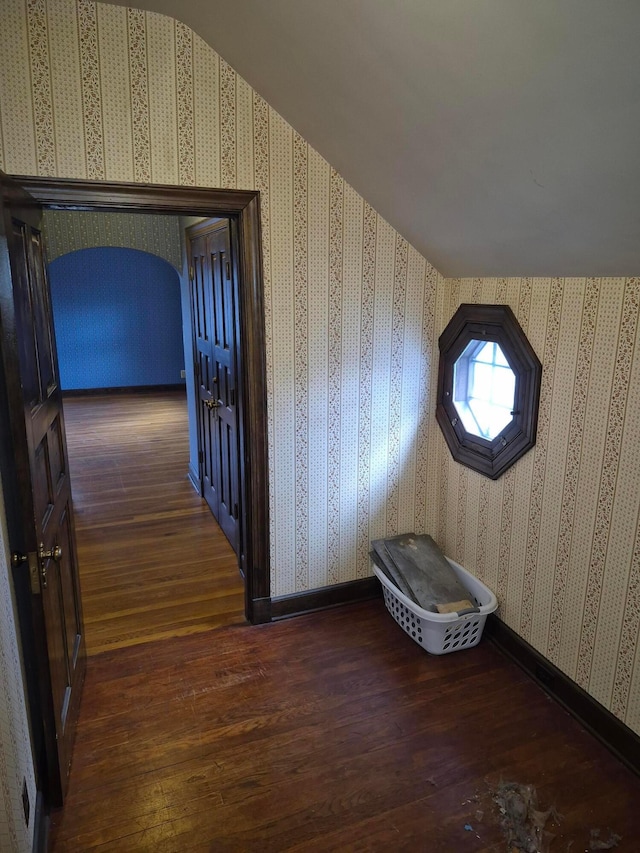 additional living space featuring wood-type flooring, baseboards, and wallpapered walls