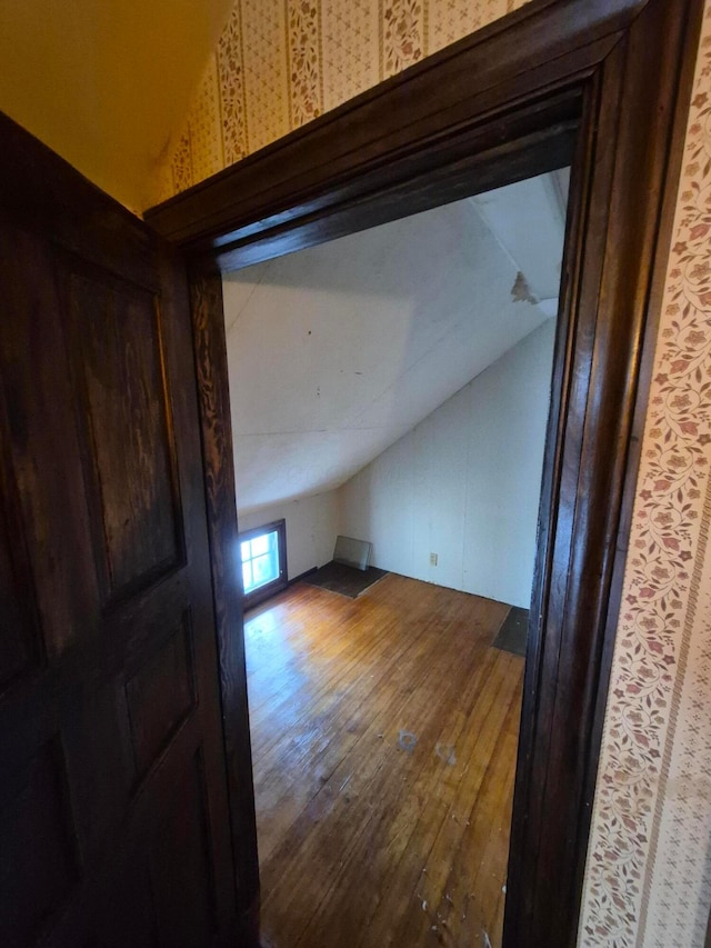 additional living space with hardwood / wood-style flooring and vaulted ceiling