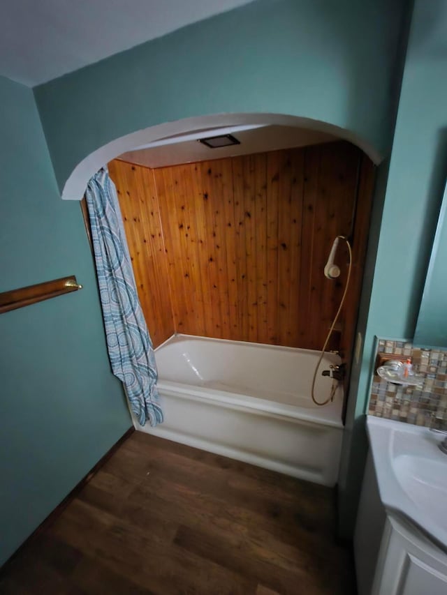 full bathroom with vanity, a bath, and wood finished floors