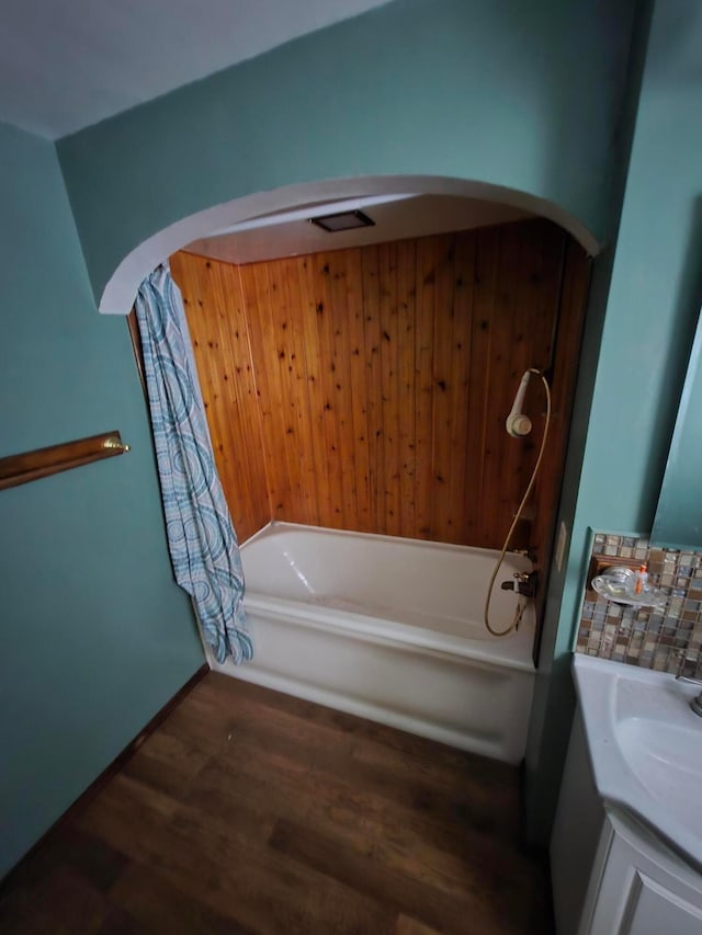 bathroom featuring a bathing tub, wood finished floors, and vanity