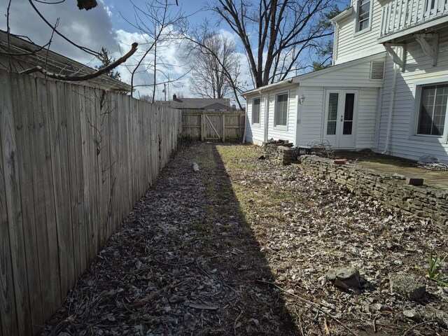 view of yard with french doors and a fenced backyard