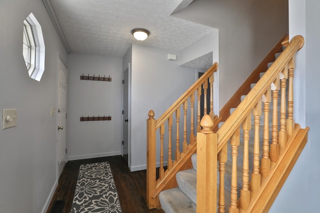 interior space featuring a textured ceiling, wood finished floors, and baseboards