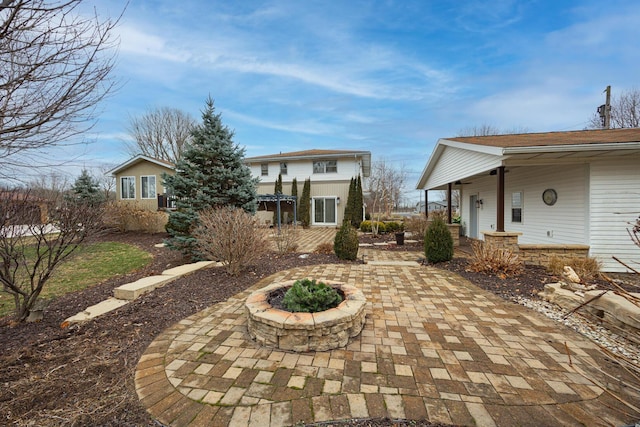 rear view of property with a patio and a fire pit