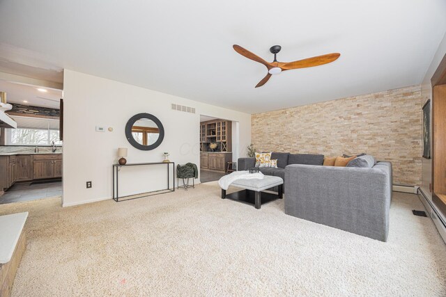 living room with a ceiling fan, visible vents, light carpet, and baseboard heating