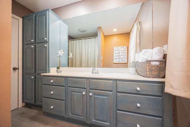 full bathroom featuring wood finished floors and vanity