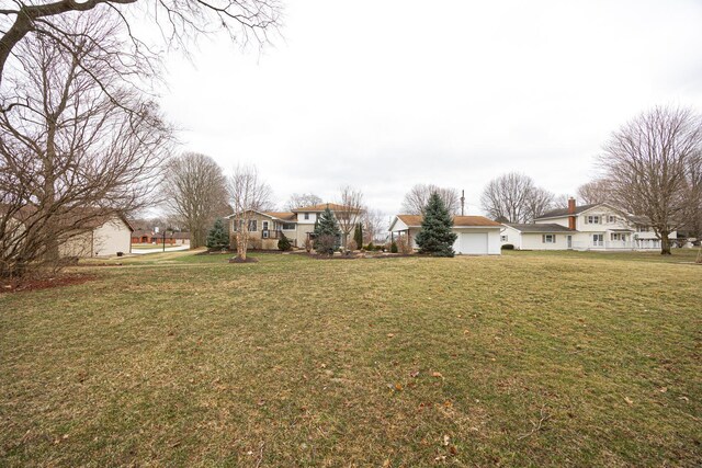 view of yard with a garage and a residential view