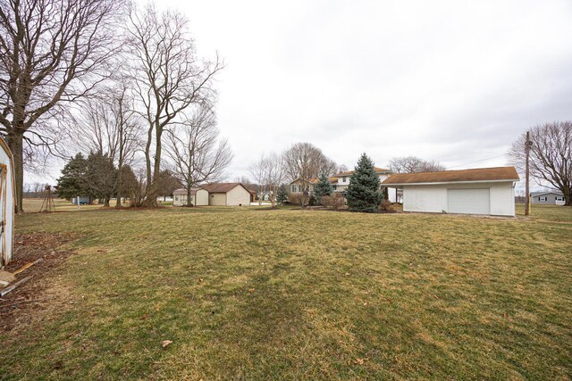 view of yard with a detached garage and an outdoor structure