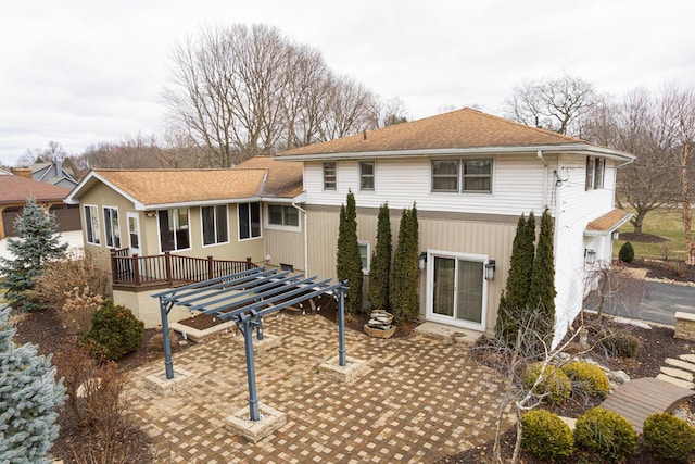 rear view of house with a patio, roof with shingles, and a pergola