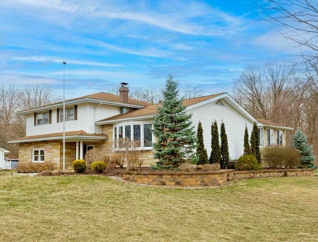 view of front of property with stone siding, a chimney, and a front lawn