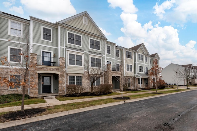 townhome / multi-family property featuring stone siding and a residential view