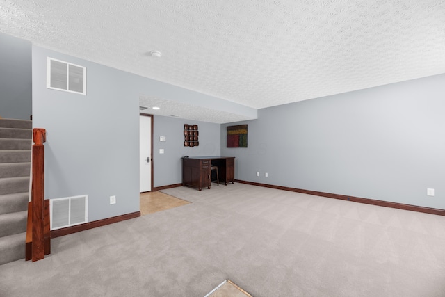 unfurnished living room with carpet floors, stairway, baseboards, and visible vents