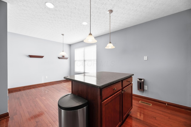 kitchen with dark wood-style floors, dark countertops, visible vents, and a textured ceiling