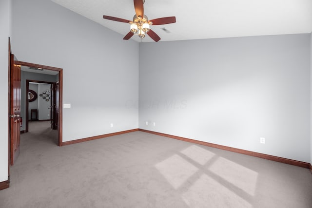 carpeted empty room with lofted ceiling, visible vents, ceiling fan, and baseboards