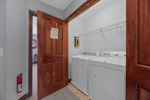 laundry room with laundry area, separate washer and dryer, and a textured ceiling