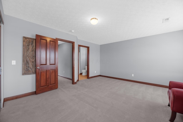 unfurnished bedroom with visible vents, baseboards, a textured ceiling, and light colored carpet