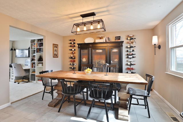 dining space with baseboards and a textured ceiling