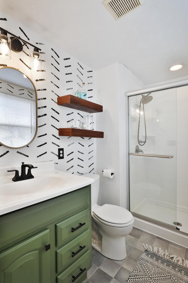 bathroom with a stall shower, visible vents, toilet, tile patterned flooring, and vanity