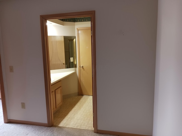 hallway with light carpet and baseboards