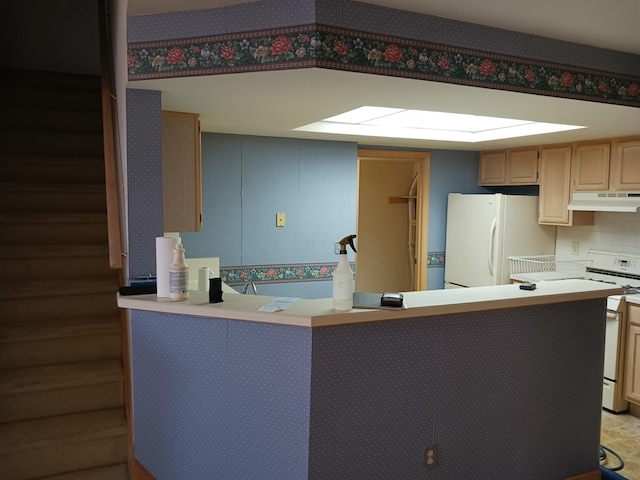 kitchen with white appliances, light countertops, under cabinet range hood, and a peninsula