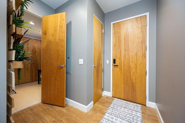 hallway featuring baseboards and wood finished floors