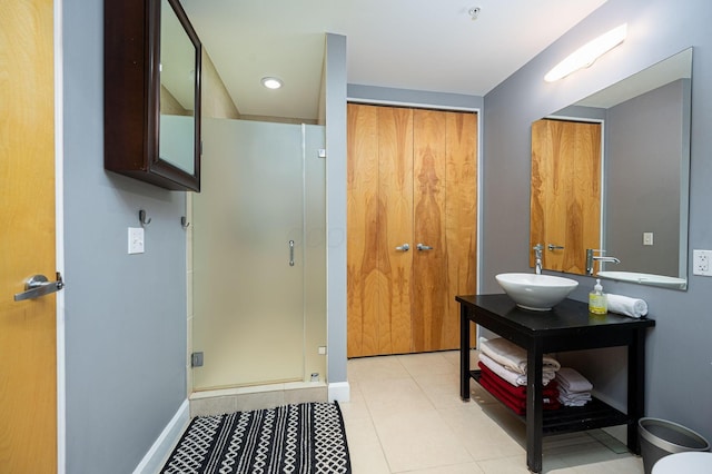 full bathroom with tile patterned flooring, vanity, baseboards, and a shower stall