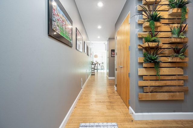 corridor with light wood-style floors, baseboards, and recessed lighting